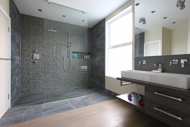 A modern bathroom with a stylish shower stall and sink.