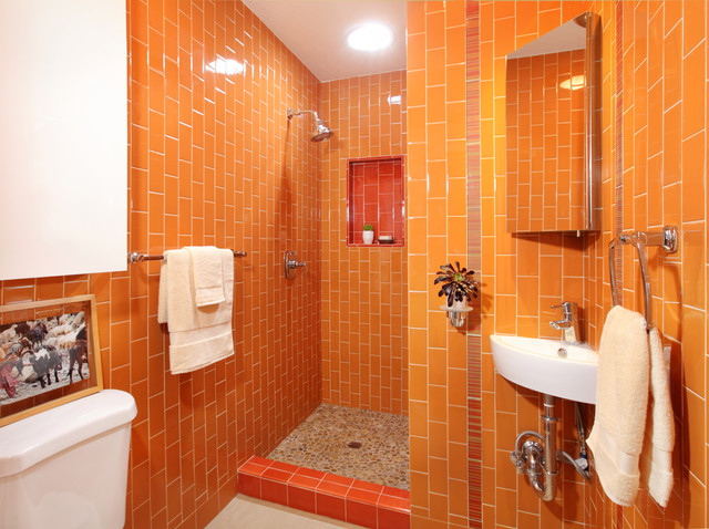 An orange tiled bathroom with a shower.