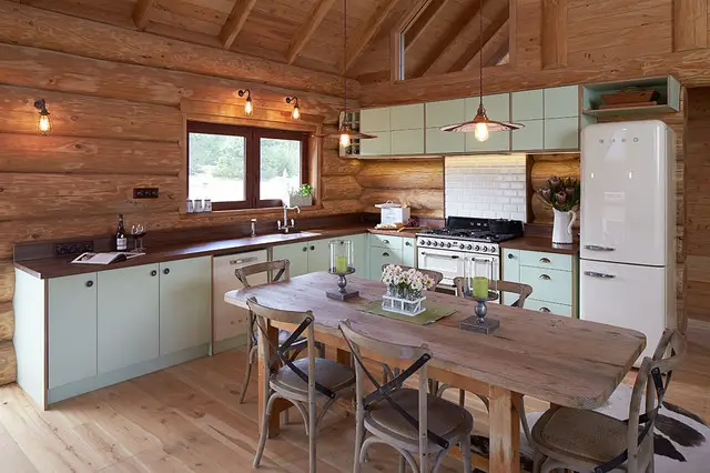 Rustic log cabin kitchen with table and chairs.