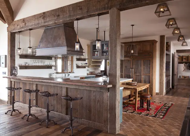 Rustic kitchen with wooden beams and bar stools.