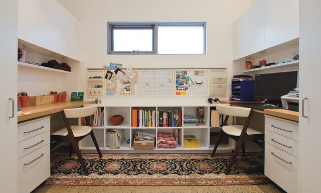 A study room with a desk and a rug.