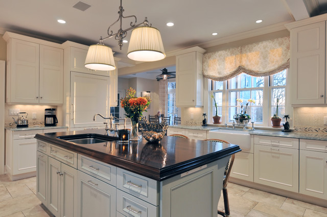 A kitchen with white cabinets and a center island, featuring a window for natural light.