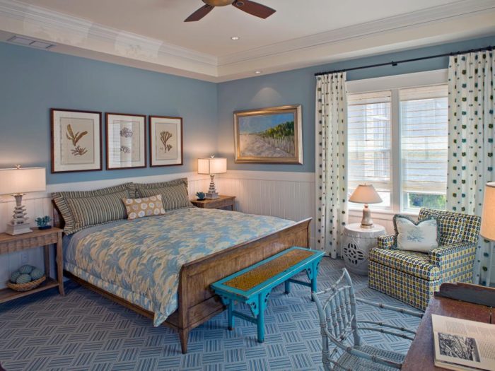 A beach style bedroom with blue walls and a ceiling fan.