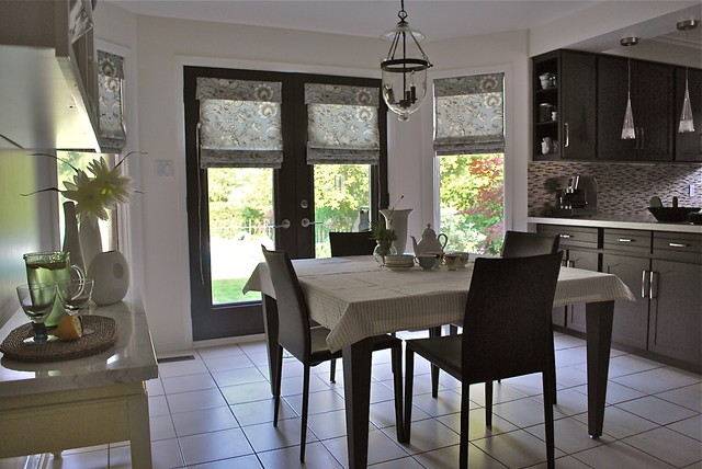 A black and white kitchen with a table and chairs, featuring stylish kitchen window ideas.