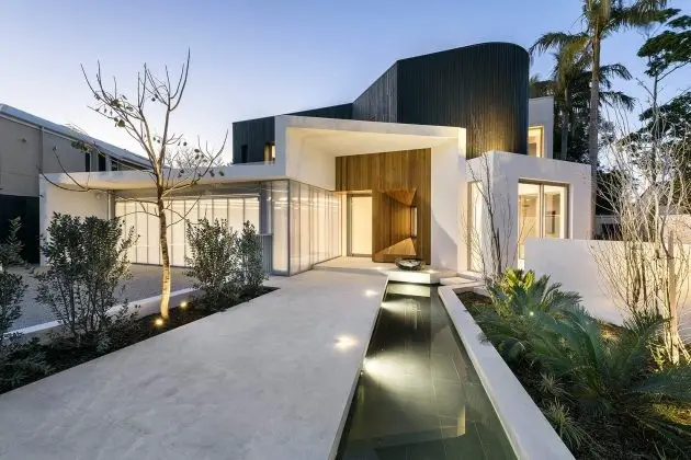 A modern home with a water feature at dusk, showcasing modern home design.