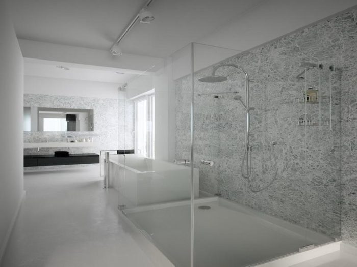 A white bathroom with a glass shower enclosure featuring modern shower design ideas.