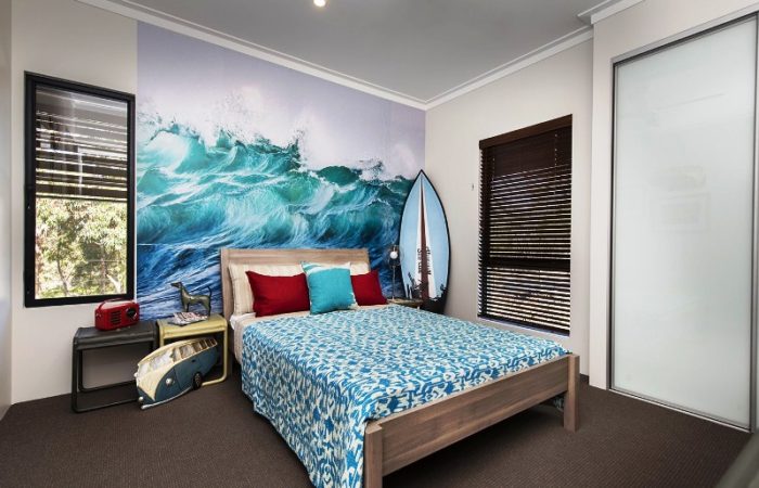 A beach style bedroom with a surfboard on the wall.