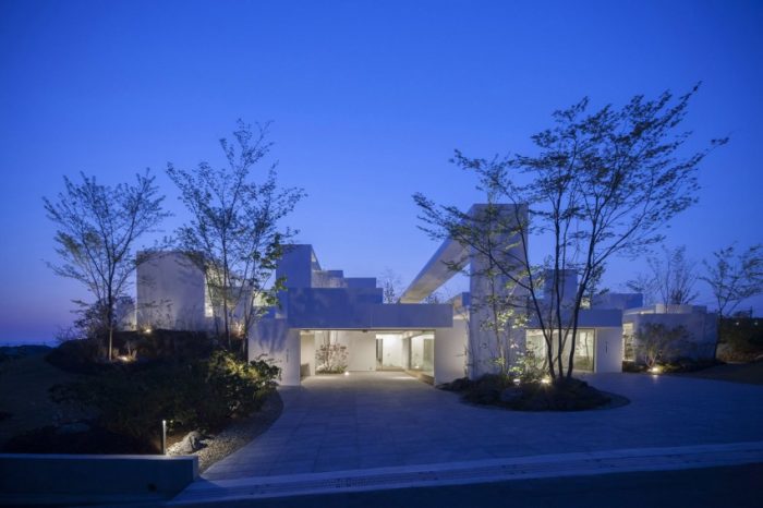 A contemporary house lit up at night.