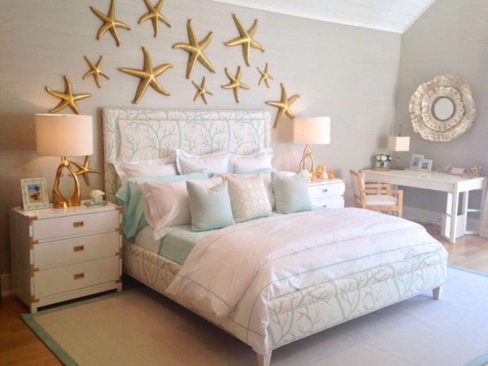 A beach style bedroom with a bed and starfish on the wall.