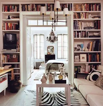 A home library with bookshelves and a zebra print rug.