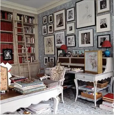 A home office with a wall covered in pictures.