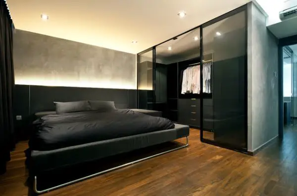 A bachelor pad bedroom featuring a black bed and wooden floors.