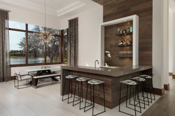A modern kitchen with a home bar and a view of the lake.