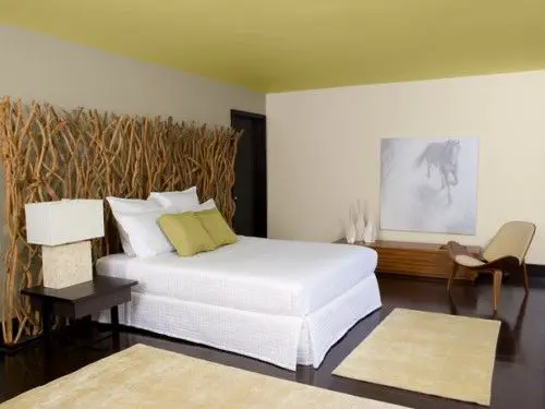 Headboard Ideas in a bedroom with a white bed and green walls.