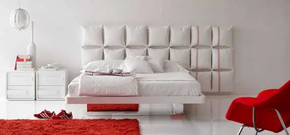 A white bedroom with a red headboard.