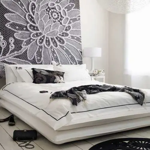 A lace headboard in a black and white bedroom.