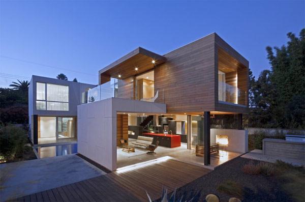 A modern house with a wooden deck at dusk showcasing modern home design.