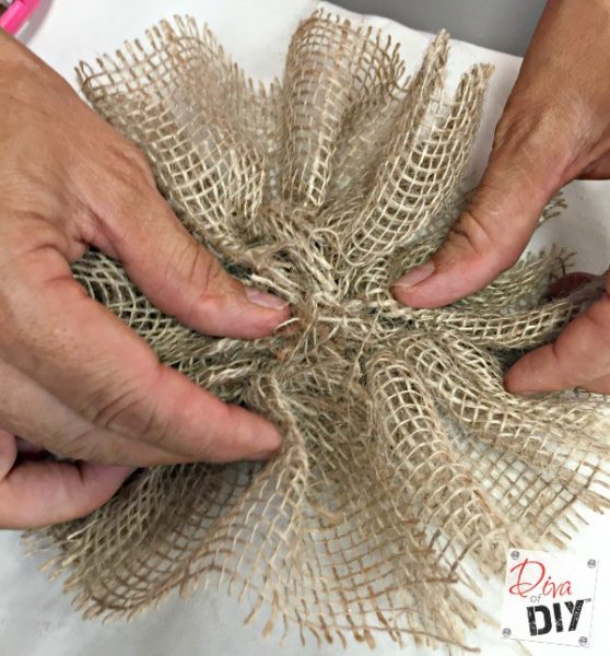 A person is making burlap flowers.