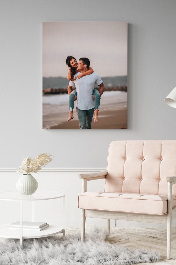 A cozy photo of a couple holding hands on a canvas in a comfortable living room.