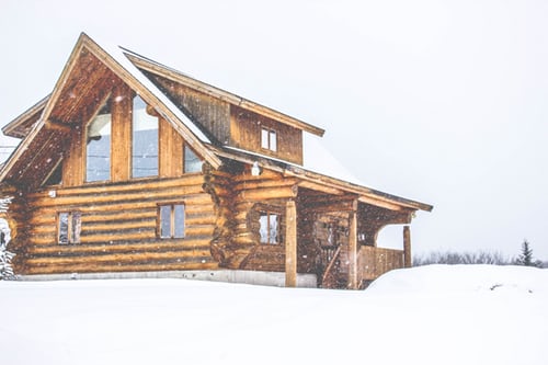 A Mountain Ridge log cabin in the snow.