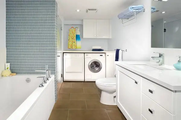 A basement bathroom with a washer and dryer.