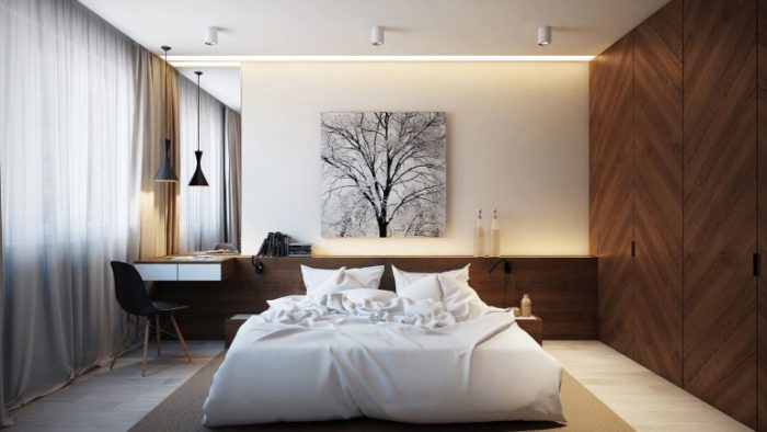 A small modern bedroom with wooden walls and a white bed.
