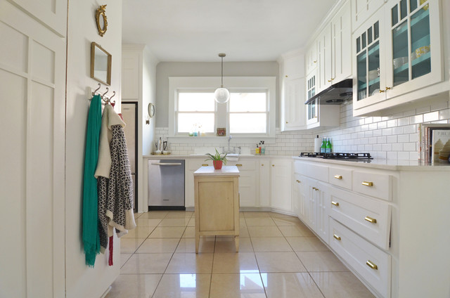 A kitchen with white cabinets and a tile floor, showcasing kitchen island ideas.