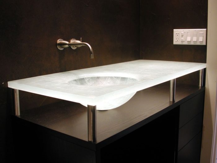 A modern bathroom sink with a sleek glass top.