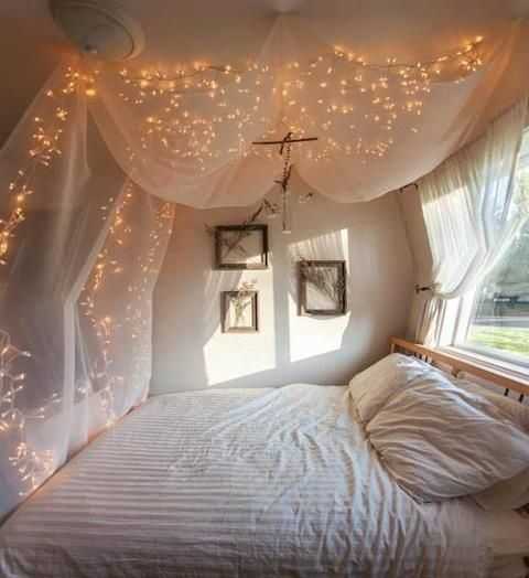 A bedroom with lights hanging over the bed.