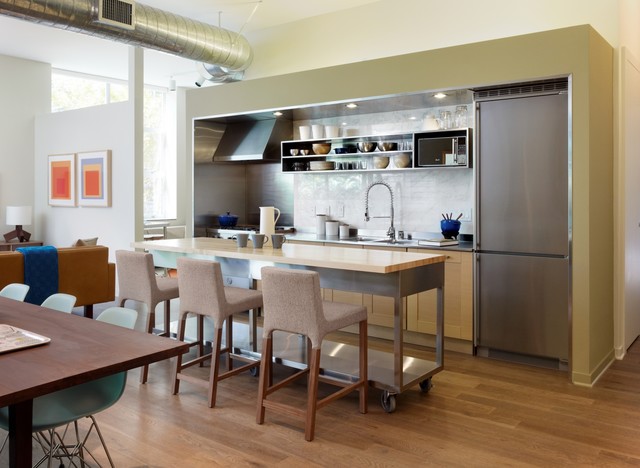 A modern kitchen with a dining table and chairs.