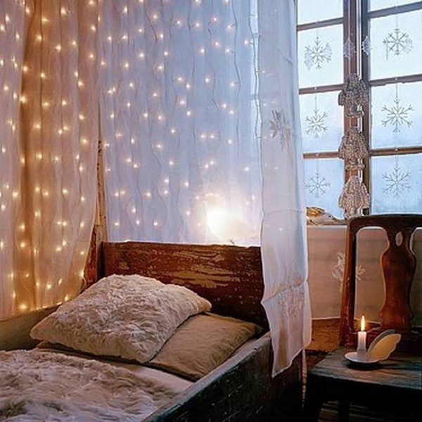 A bedroom with a bedside table and string lights.