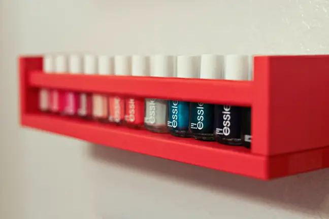 Red nail polish holder for bathroom storage space.
