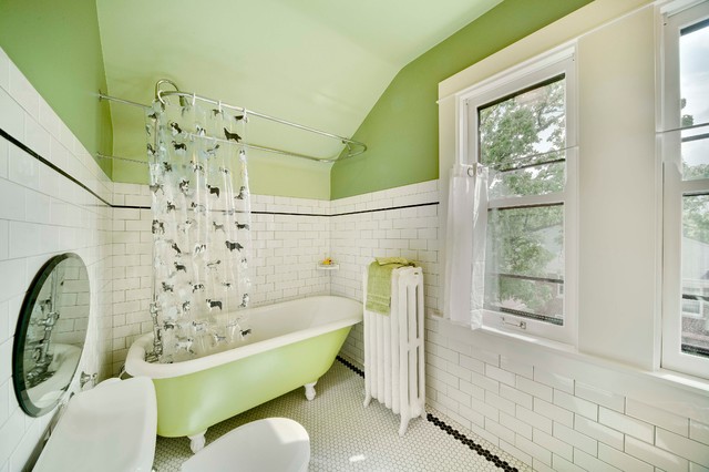 A bathroom with green tile walls and a green tub.