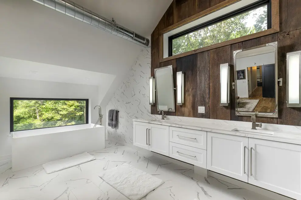 A rustic white bathroom with wood paneling and a window.