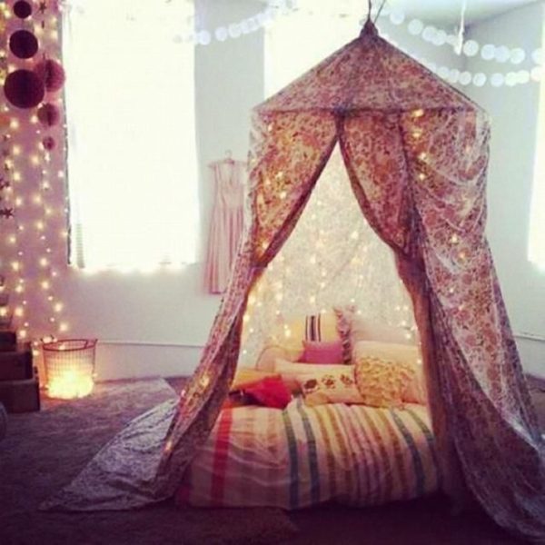 A cozy bedroom featuring a bed adorned with string lights.