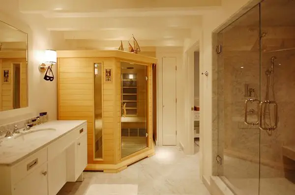 A basement bathroom with a sauna and a glass shower.