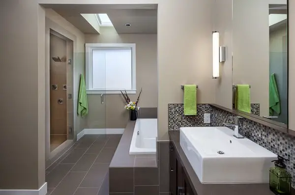 A modern basement bathroom with a bathtub and sink.