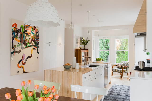 A kitchen with a table, chairs, and a painting on the wall, ideal for kitchen island ideas.