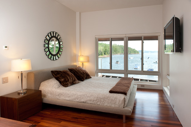 A small master bedroom with a view of the water.