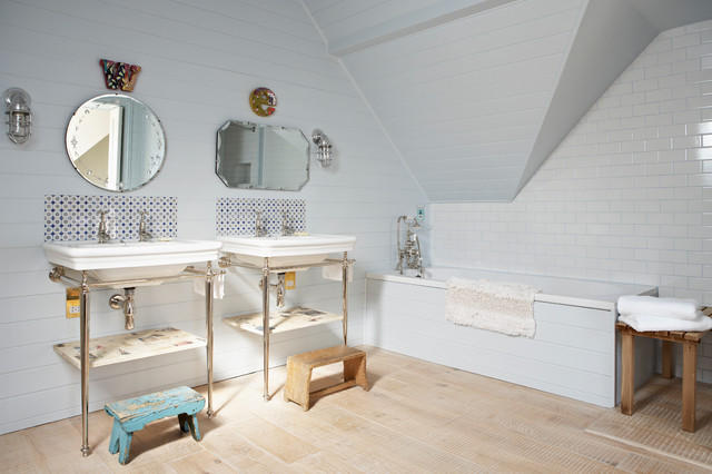 A white bathroom with two sinks and a bathtub showcasing modern bathroom tile ideas.
