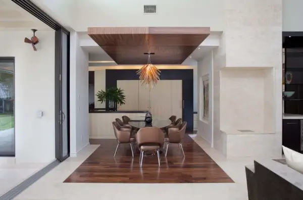 A modern living room with a dining table and chairs featuring a stylish dining room ceiling.