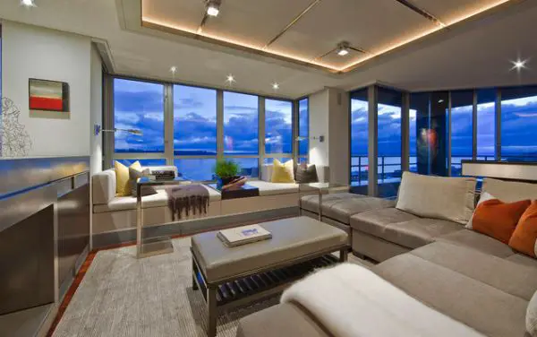 A living room with large windows and high ceiling overlooking the ocean.