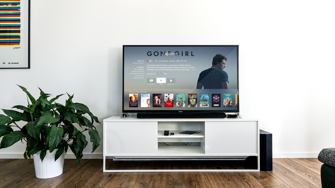 A tv stand with a TV on it displaying Apple TV Plus.