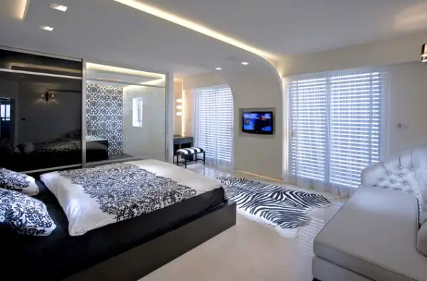 A bedroom with a zebra print bed.