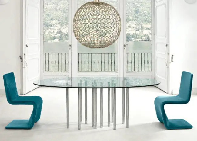 A dining room with a glass table serving as the centerpiece.