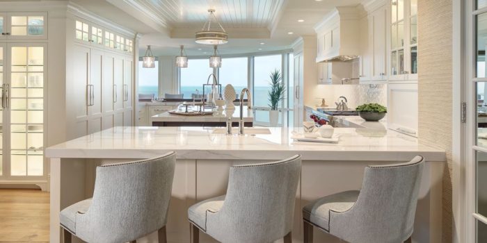 A kitchen with a white cabinet makeover and a view of the ocean.