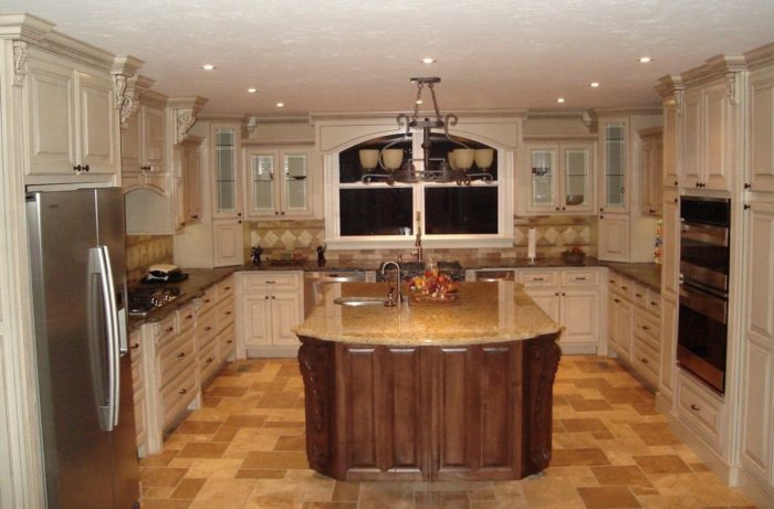 A small kitchen with a center island and granite counter tops.