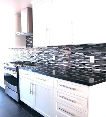 Black and white kitchen with white cabinets and black appliances.