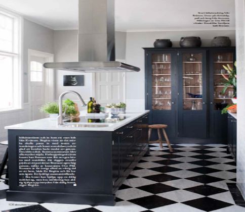 A monochrome kitchen with a checkerboard floor.