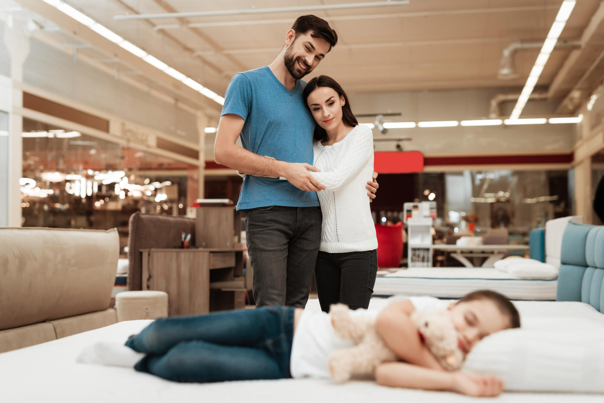 A couple with a child browsing furniture store.